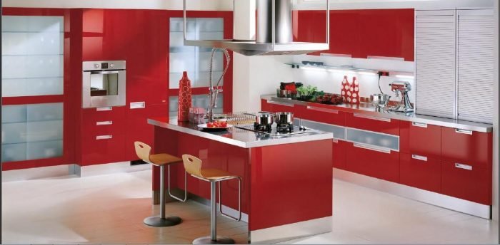 A modern kitchen with red cabinets and stainless steel appliances.