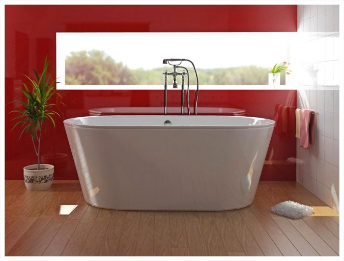 A modern bathroom with red walls and a white bathtub.