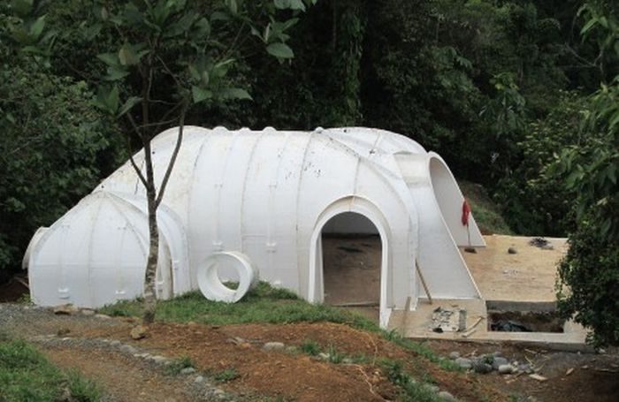 A white dome resembling a Hobbit home is sitting on top of a hill.