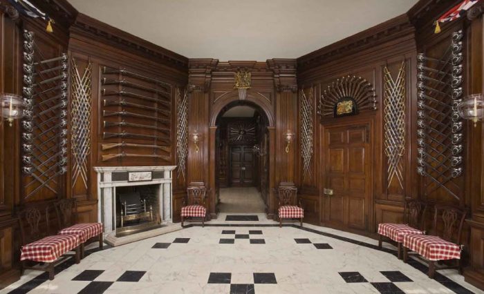 A Governor's Palace featuring an ornate room with wood paneling and a fireplace.