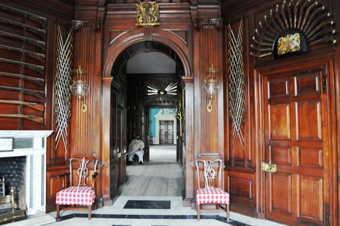 The Governor's Palace hallway with wooden doors and a checkered floor.