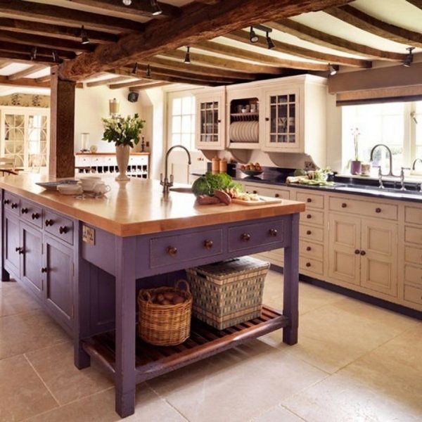 A kitchen with a spacious island and rustic wooden beams.
