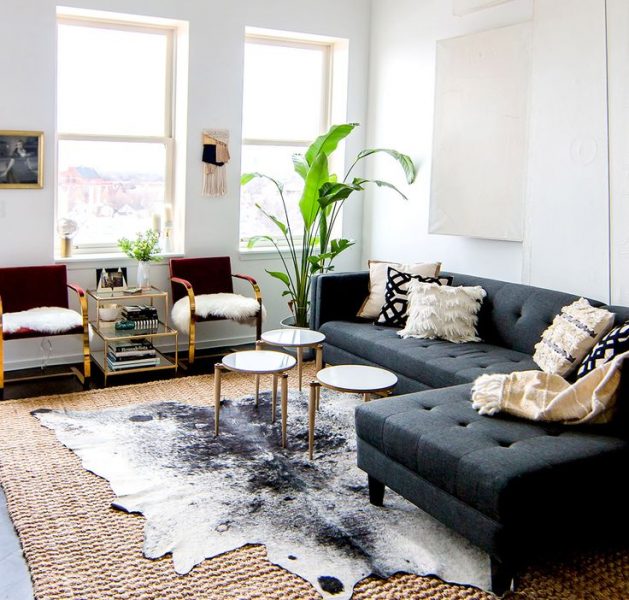 A living room showcasing layering textures with a cowhide rug.