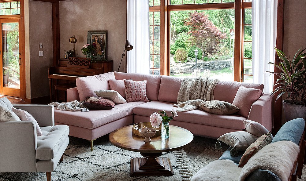 A living room featuring layering textures in a pink couch and coffee table.