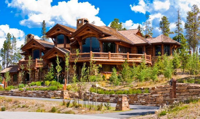 A large log cabin on a hillside.