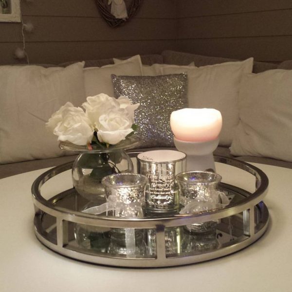 A silver tray adorned with candles, flowers, and mirrors.