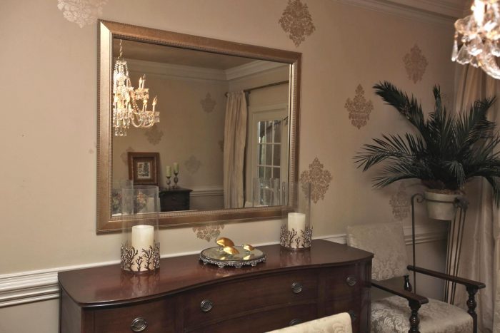 A formal dining room with a mirror.