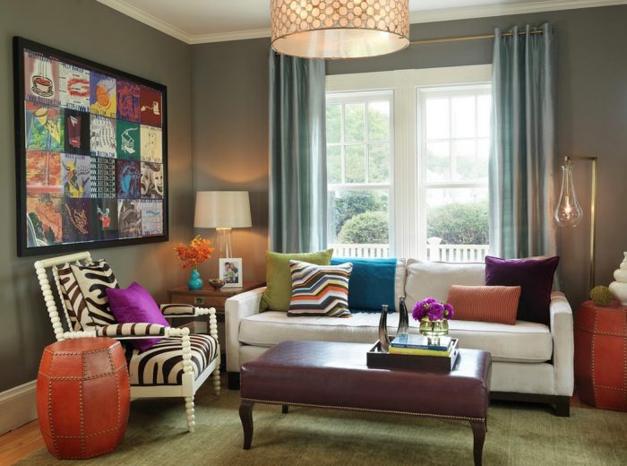 A living room with mixing patterns of colorful pillows and zebra rugs.