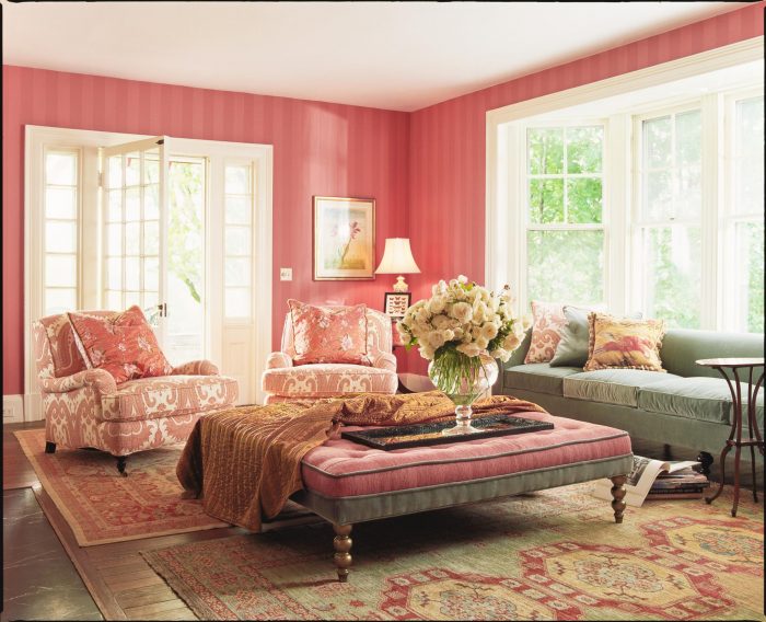 A living room with pink walls featuring mixing patterns.