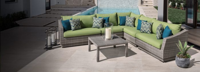 A patio furniture set with green cushions, perfect for entertaining.