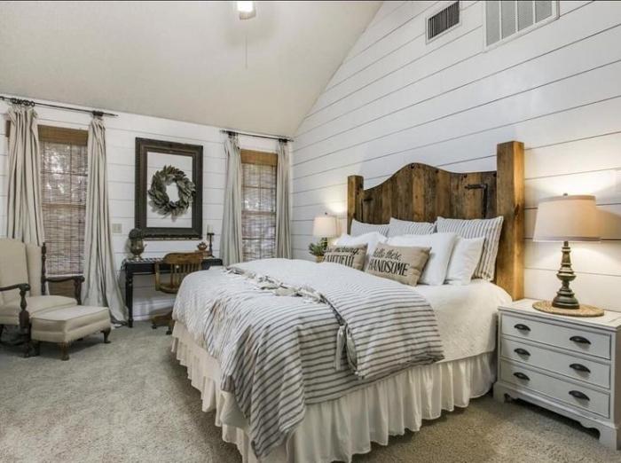 A rustic bedroom with wood paneling and farmhouse touches.