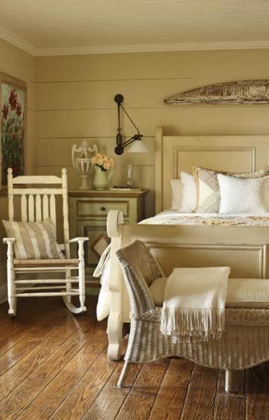 A rustic bedroom with wooden floors and farmhouse touches, featuring a rocking chair.