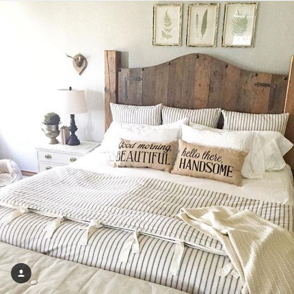 A bed with a striped headboard and pillows featured in a pleasingly rustic bedroom.