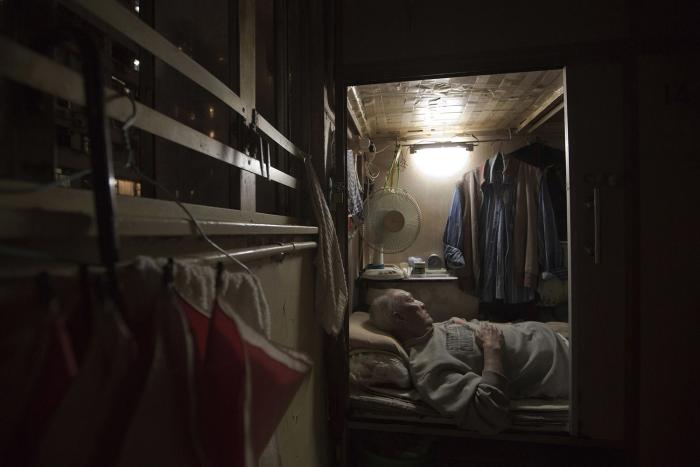 A man is sleeping in a small room in Hong Kong's 'coffin homes'.