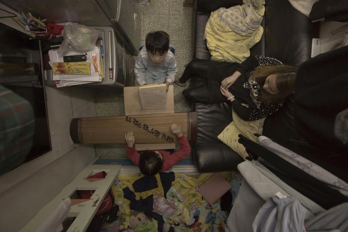 A child is playing inside a cramped space in a living room.