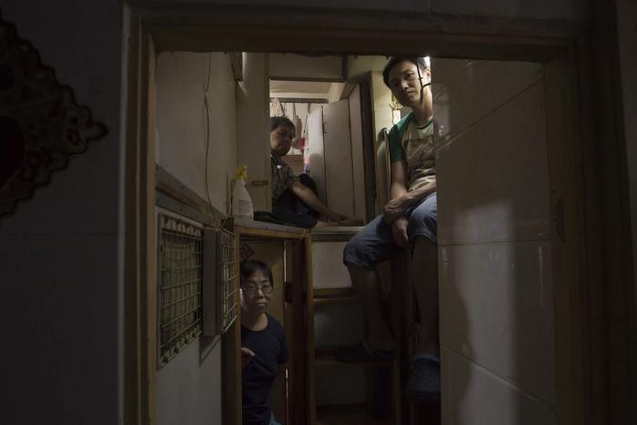 Unbelievable Life Inside Hong Kong's 'coffin homes' captures a group of people in a doorway.
