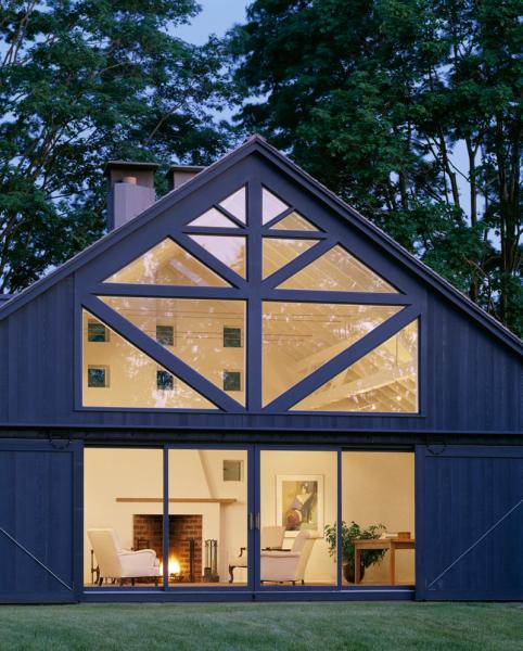 A modern American barn with glass windows and a fireplace.