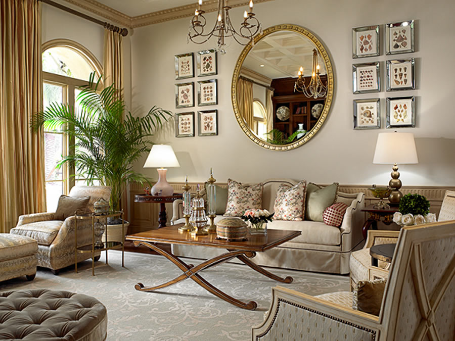 A living room with furniture decorated with gold accents and a large mirror.