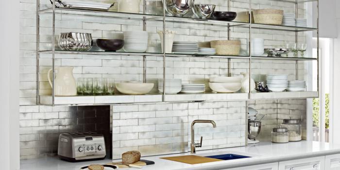 A kitchen with white tiled wall and shelves following kitchen trends 2017.