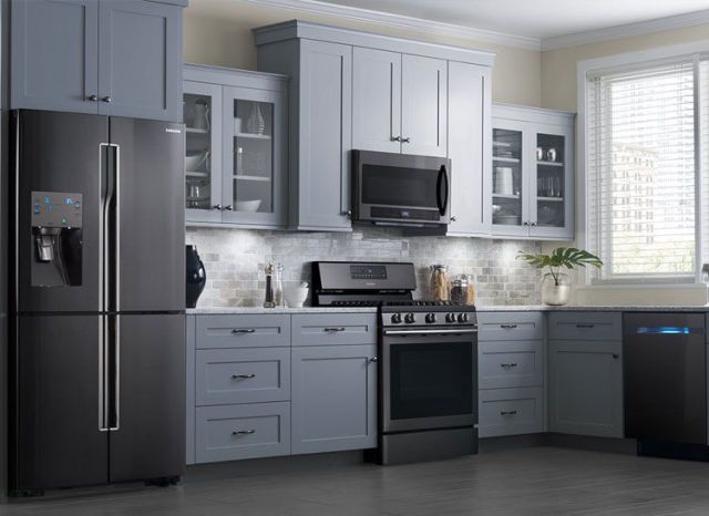 A trendy kitchen with black appliances and gray cabinets.