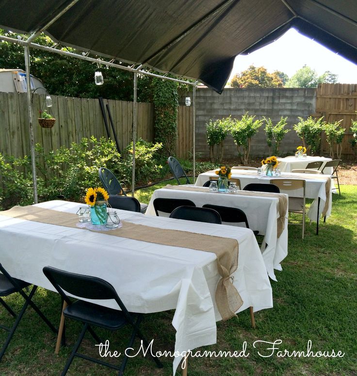 A backyard cookout decor featuring a table set up with sunflowers and burlap.
