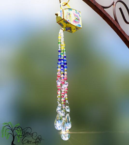 A colorful sun catcher hanging from a tree.