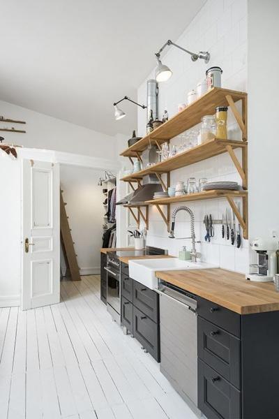 A Swedish kitchen with wooden shelves and a wooden floor.