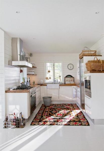 A Swedish kitchen with a rug on the floor.
