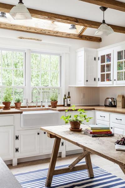 A Swedish kitchen with wooden beams and a blue striped rug.