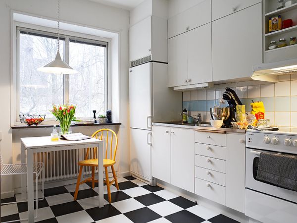A Swedish kitchen with a black and white checkered floor.