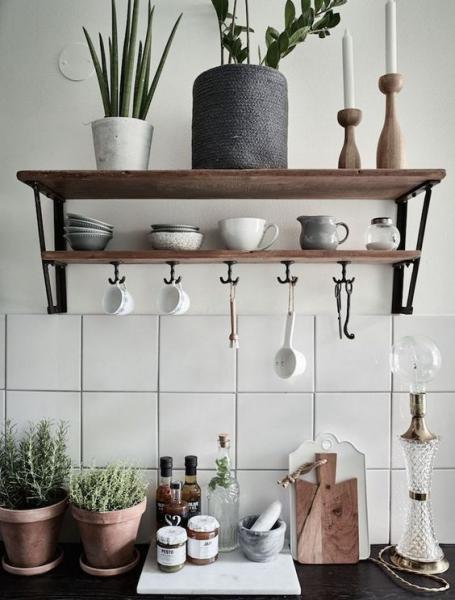 A wooden shelf with potted plants and pots, showcasing a Swedish Kitchen aesthetic.