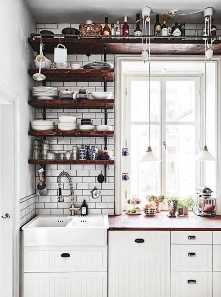 A white Swedish kitchen with wooden shelves and a sink.