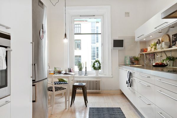 A Swedish kitchen with white cabinets and a wooden floor.
