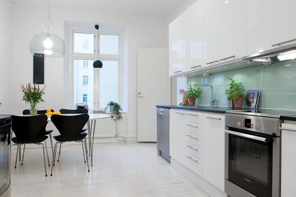 A Swedish kitchen with white cabinets and stainless steel appliances.