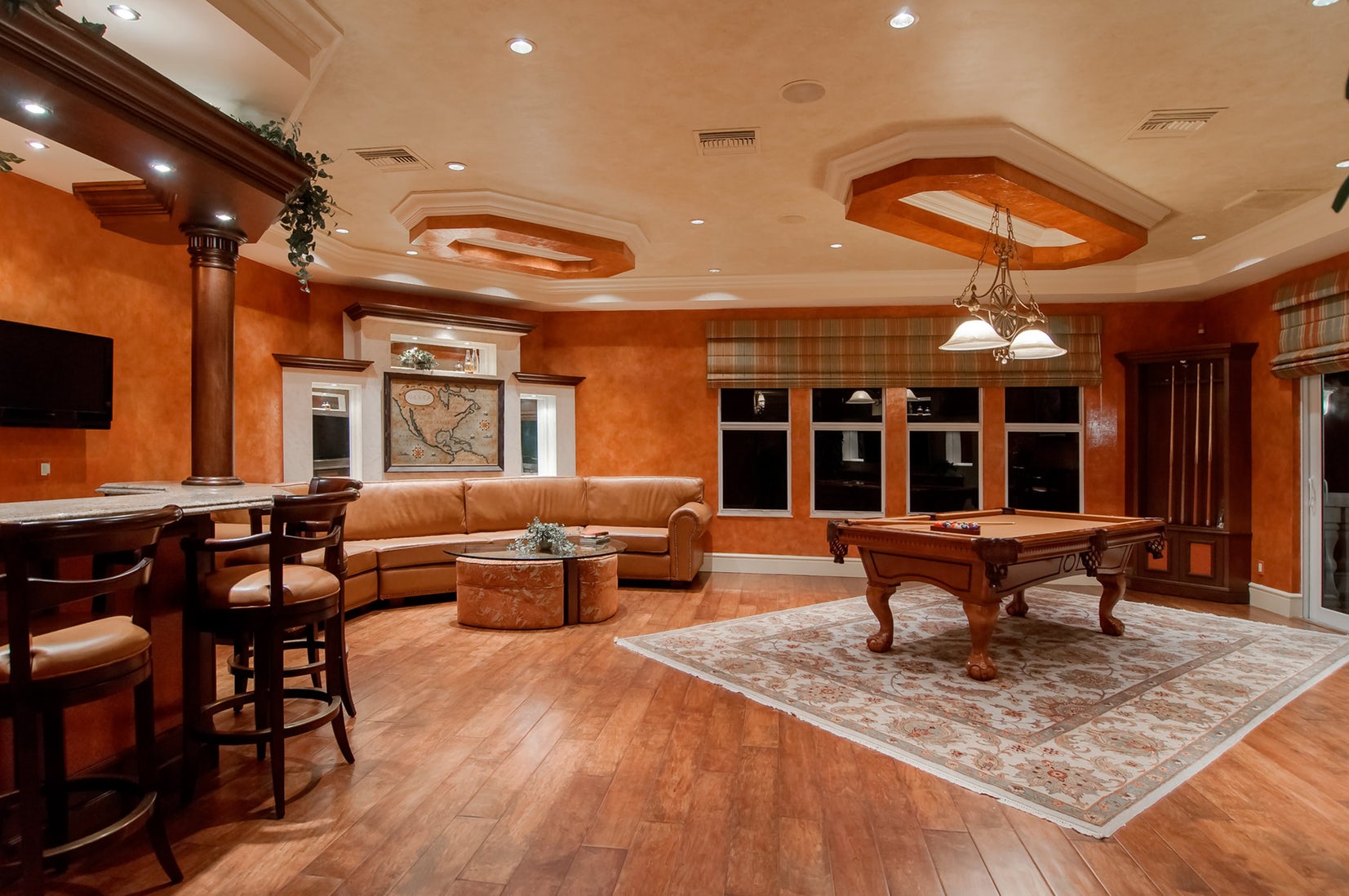 A spacious living room with a pool table and bar.