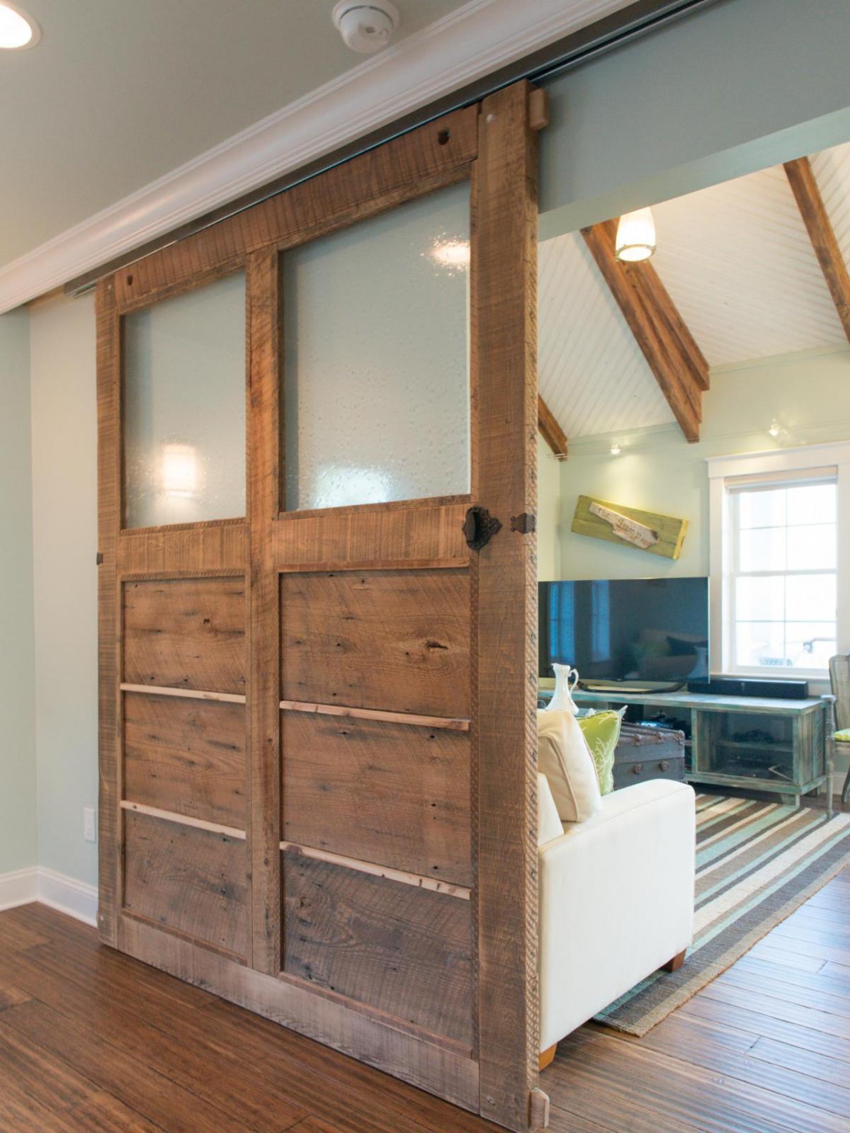 A reclaimed wood sliding barn door in a living room.