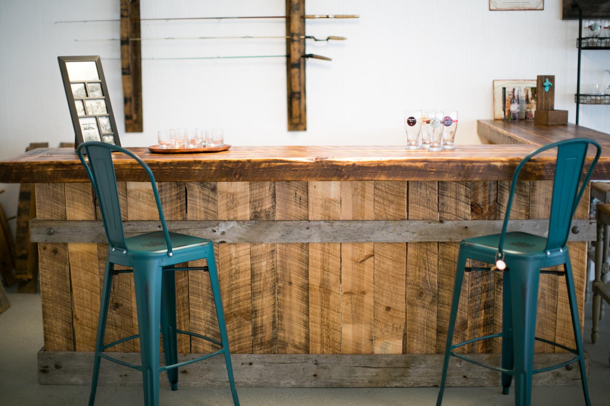 A reclaimed wood bar with two stools in front of it.
