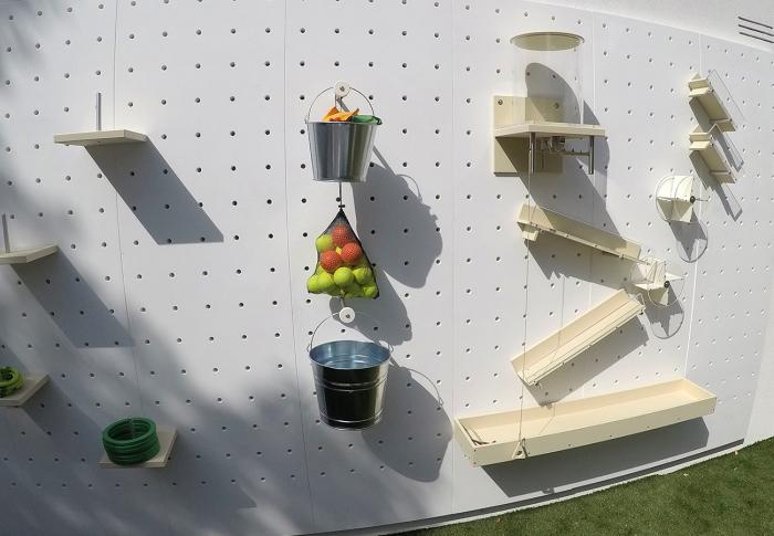 A creative contemporary play wall with fruit hanging on pegs.