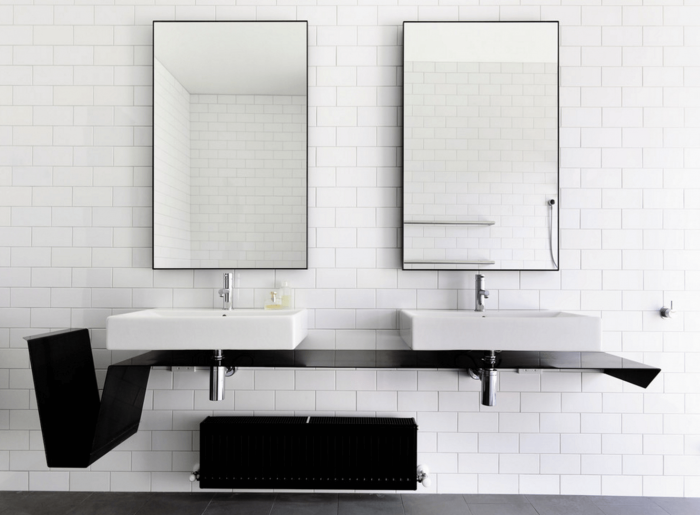 A black and white bathroom with two sinks and mirrors.