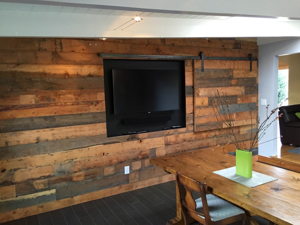 A living room with a reclaimed wood wall and a tv.