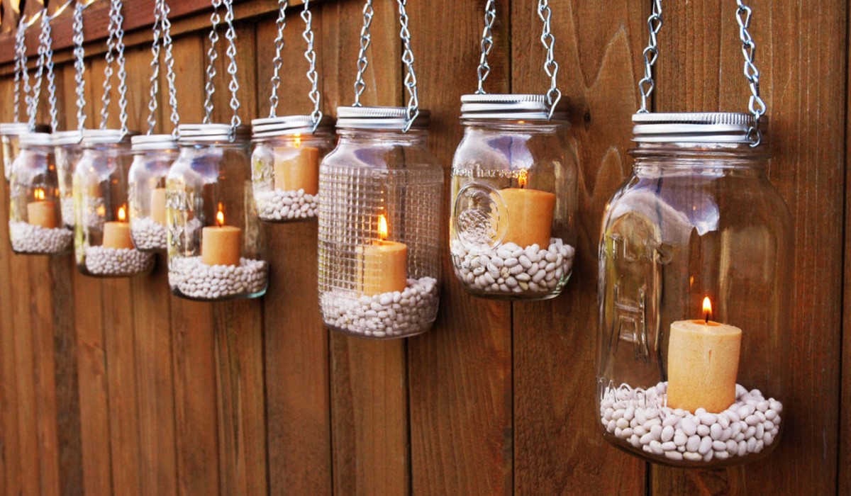 Mason jars hanging on a wooden fence.