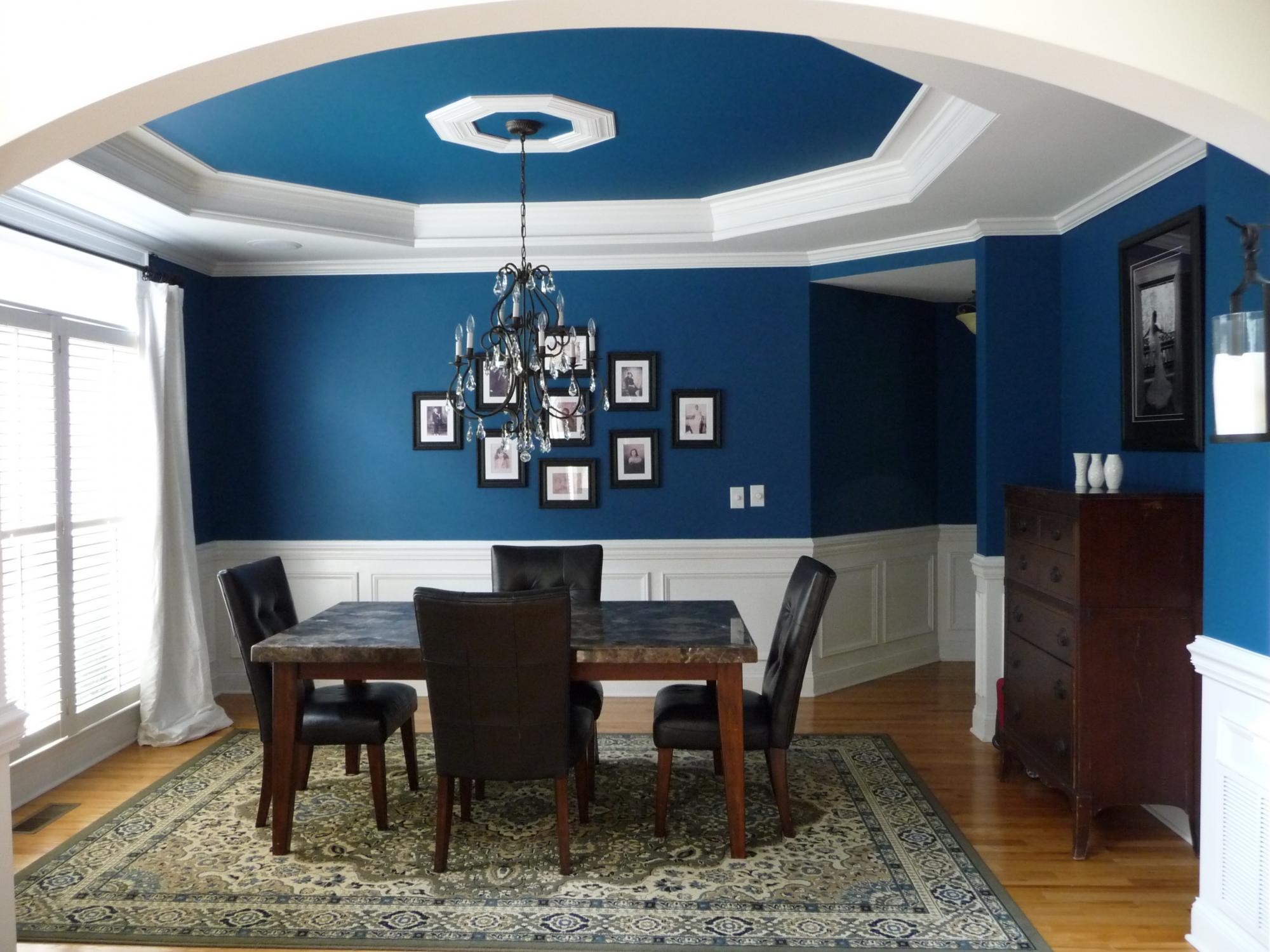 A oceanside dining room with blue walls and black furniture.