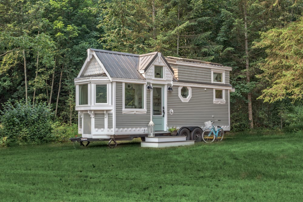 A tiny home in the woods with a bicycle.