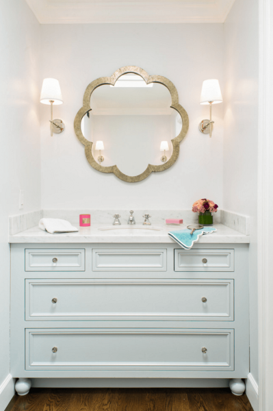 A white vanity and mirror in a bathroom.