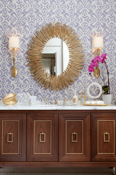 A bathroom with a gold vanity and a mirror.