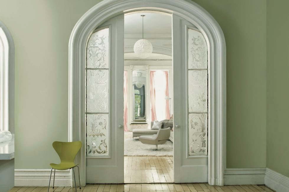An arched doorway in a room with green walls painted with classic paint colors.