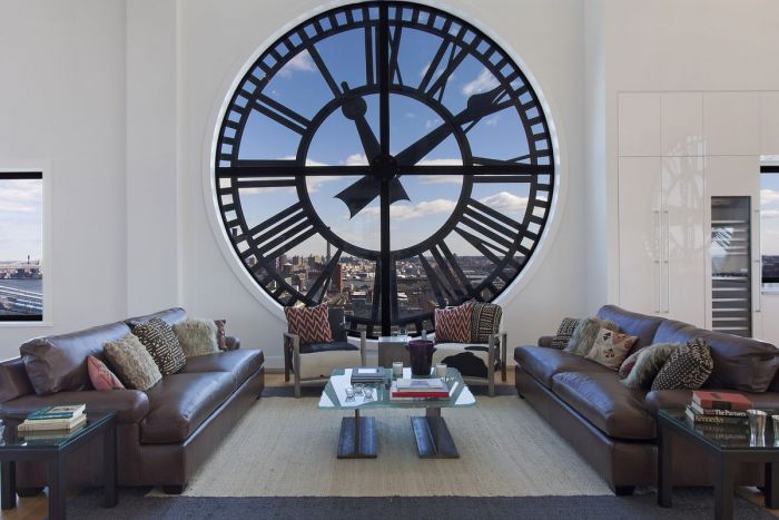 A large clock in the middle of a New York City penthouse living room.