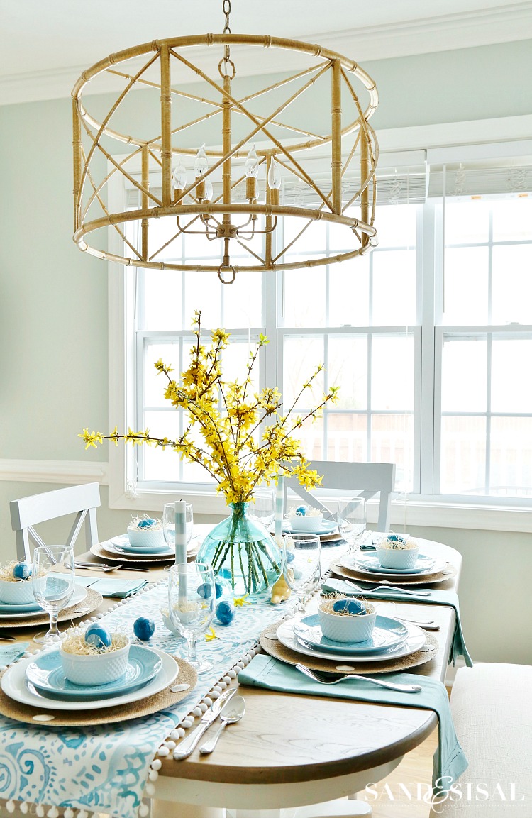 A blue and white dining room with a gold chandelier perfect for Easter gatherings.