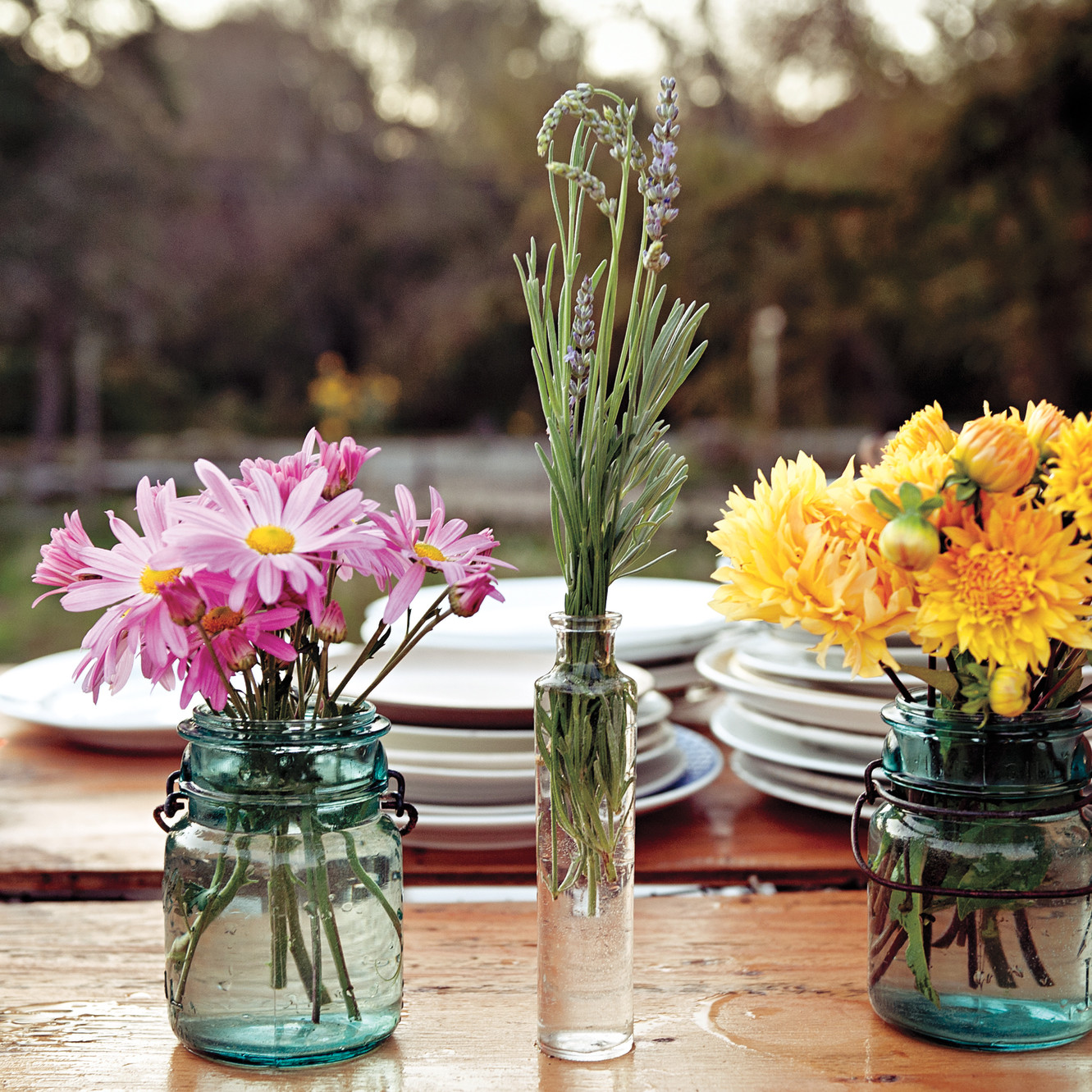 Three vases of flowers on a table featuring home decorating.