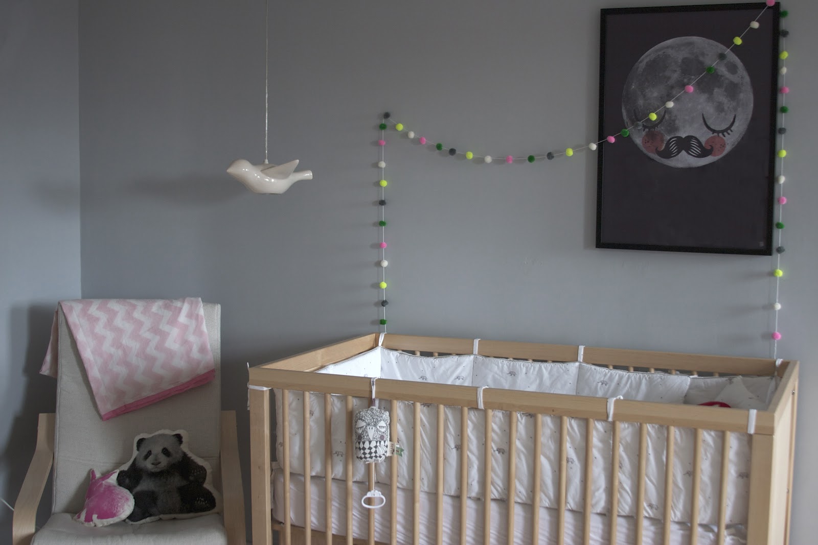 A baby's room with a classic grey crib.
